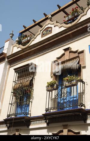 Tipica casa di Siviglia con balcone decorato con piastrelle azulejos. Come mostrato nella parte superiore della facciata, questa abitazione fu costruita nel 1938 Foto Stock