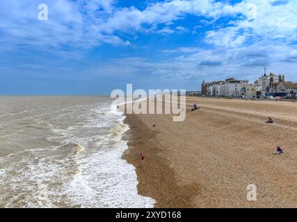 La spiaggia di ciottoli e il lungomare di Deal, Kent, Regno Unito. In una giornata luminosa e ventilata all'inizio di giugno con foschia in lontananza. Le scogliere distanti sono Kingsdown. Foto Stock