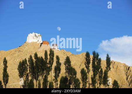Il castello di Tsemo e Namgyal Tsemo Gompa sulla cima di una montagna con luna crescente visto dalla distanza del teleobiettivo in Leh, Ladakh, India. Posizione orizzontale Foto Stock