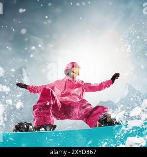 Snowboarder vestito con una vivace attrezzatura rosa che percorre la pista con precisione, mostrando abilità e adrenalina di un'esperienza di snowboard. Foto Stock