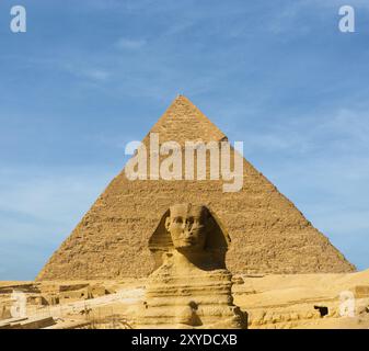 La Grande Sfinge faccia avanti centrato davanti al più grande piramide egizia di Khafre in Giza, Cairo, Egitto su un cielo blu al giorno. Un sacco di spazio di copia Foto Stock