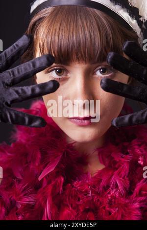 Una giovane donna con boa in piuma in stile anni '20 una giovane donna con boa in piuma in stile anni '20 Foto Stock