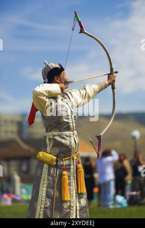 Ulaanbaatar, Mongolia, 11 giugno 2007: Una donna mongola splendidamente vestita archer che punta la sua freccia al tradizionale Naadam Festival tiro con l'arco femminile Foto Stock