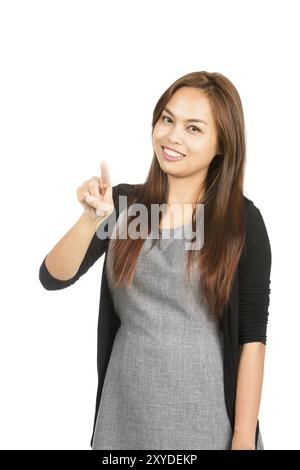 Adorabile donna asiatica in abiti casual con capelli marrone chiaro, pressione del dito indice, interazione con il pulsante immaginario o l'interfaccia touchscreen Foto Stock