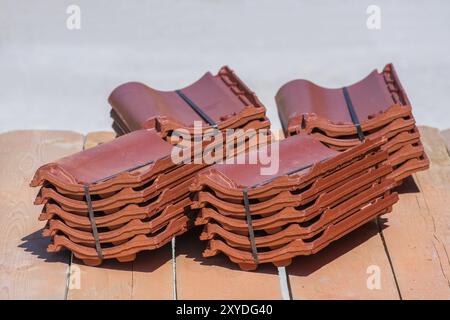 Pile di pallet nuovi di tegole del tetto giacciono su impalcatura di legno pannelli Foto Stock