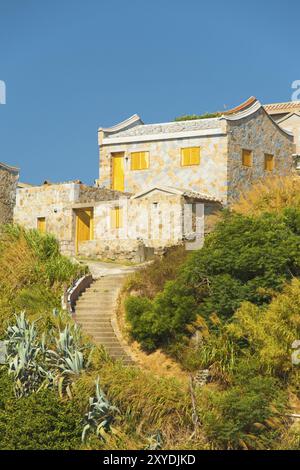 I gradini ricurvi conducono ad una casa in mattoni splendidamente costruita in stile Fujian sull'isola di Juguang sulle Isole Matsu a Taiwan. Verticale Foto Stock