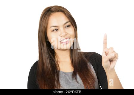 Ritratto di una bella donna asiatica in maglione nero con capelli marroni chiari che guardano lontano al dito indice sollevato premendo il pulsante immaginario o lo schermo. T Foto Stock