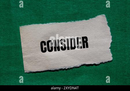 Considerare il messaggio scritto su un pezzo di carta strappato con sfondo verde. Simbolo concettuale da considerare. Copia spazio. Foto Stock