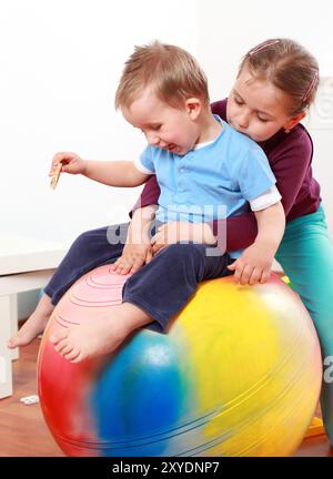 I ragazzi hanno un divertimento con la palla ginnica Foto Stock