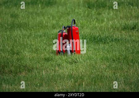 Estintore in un prato vicino a una pista da corsa Foto Stock