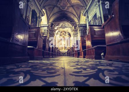 Impressionati della Chiesa cattolica in Italia con antichi banchi in legno e un bellissimo altare Foto Stock