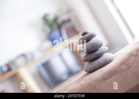 Feng Shui: Cairn di pietra in primo piano, salotto sfocato sullo sfondo. Equilibrio e relax Foto Stock