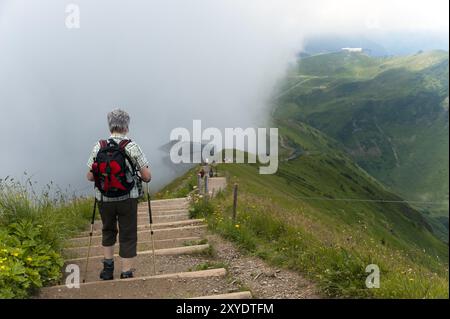 Donna che cammina verso la stazione sommitale della funivia Fellhorn Foto Stock