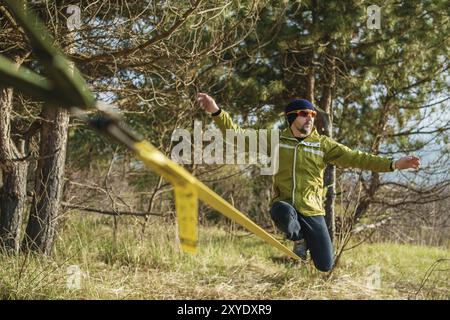 Un uomo all'età di sedersi su una linea lenta, trovare equilibrio e godersi la vita Foto Stock