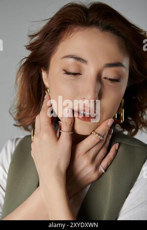 Una donna con i capelli corti e ricci marroni, che indossa un gilet verde Foto Stock