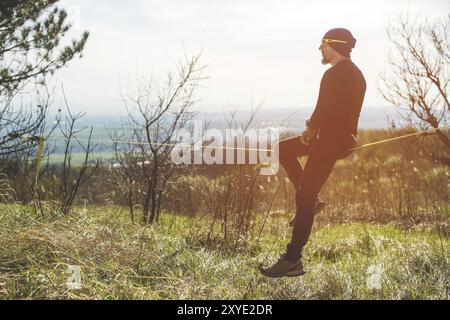 Un uomo all'età di sedersi su una linea lenta, trovare equilibrio e godersi la vita Foto Stock