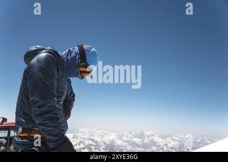 Guida professionista completamente attrezzata, arrampicatore sulla cima innevata del vulcano Elbrus addormentato Foto Stock