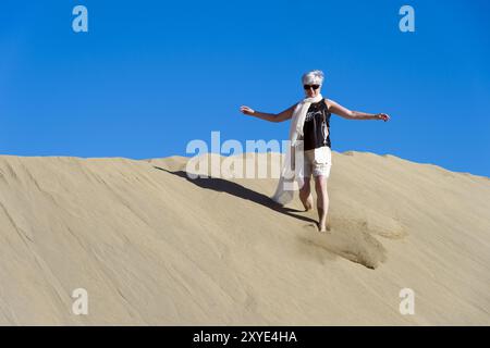 Un cittadino anziano corre lungo le dune di Maspalomas Foto Stock