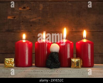 Quattro red Avvento candele su un rustico sfondo di legno, tutte le candele accese, Quarto Avvento, Natale sfondo concept Foto Stock