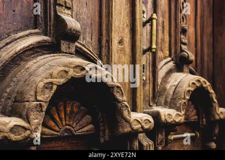 Sfondo vintage. Elementi di una vecchia porta in legno intagliato decorati con voluminosi elementi in legno intagliato che imitano la tessitura. Un concetto vintage di Foto Stock