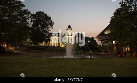 Una vista illuminata del municipio nella città di Duluth in Georgia scattata al tramonto con una fontana in primo piano Foto Stock