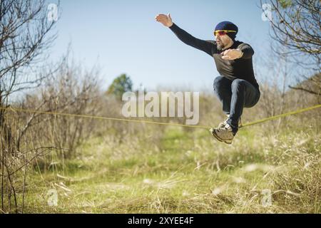 Un uomo all'età di sedersi su una linea lenta, trovare equilibrio e godersi la vita Foto Stock