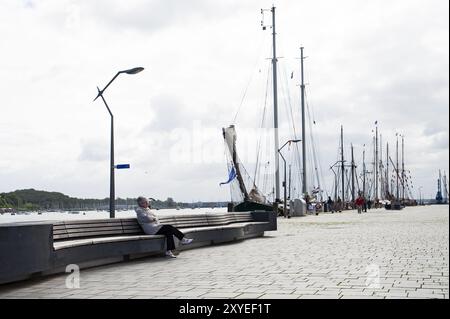 Donna solitaria seduta su una panchina nel porto di Eckernfoerde Foto Stock