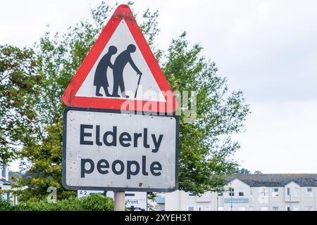 Segnaletica stradale che avverte gli automobilisti di prestare attenzione agli anziani che attraversano il lungomare. Ballycastle, Regno Unito - 24 agosto 2024. Foto Stock