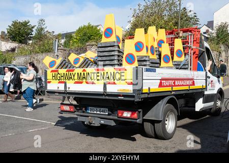 Autocarro per la gestione del traffico per la manutenzione stradale carico di pile di coni stradali gialli e blu. Ballycastle, Regno Unito - 26 agosto 2024. Foto Stock