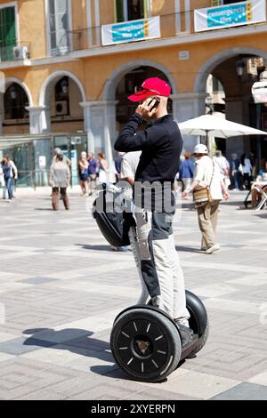 Uomo che parla al telefono con il suo Segway Foto Stock