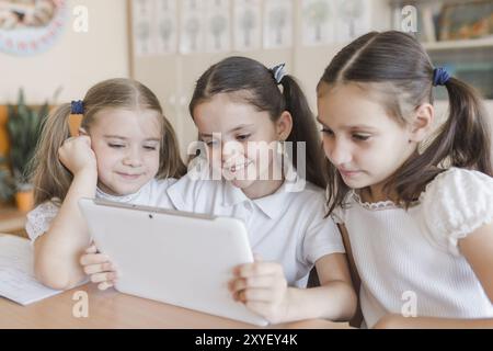 Ragazza allegra che usa un tablet in aula Foto Stock