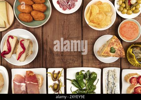 La cucina di Spagna. Una foto aerea di molti diversi tapas spagnoli, ripresa dall'alto su un rustico scuro texture. Jamon, formaggio, vino, olive, crocchetta Foto Stock