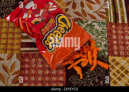 Cheetos croccante con un bicchiere di latte. Charles Elmer Doolin inventò Cheetos nel 1948, Frito-Lay è una filiale della PepsiCo. Chester Cheetah-Mascot! Foto Stock