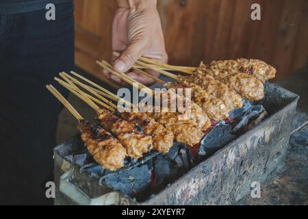 Sate Buntel o Satay Buntel è un satay di montone sminuzzato avvolto nel grasso di montone che viene grigliato su carbone. Foto Stock