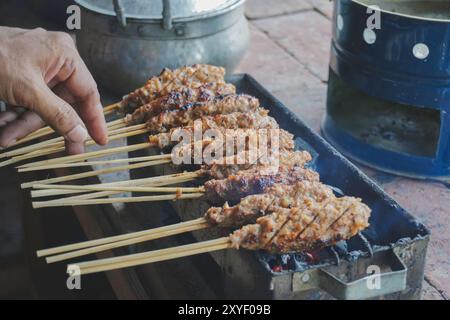 Sate Buntel o Satay Buntel è un satay di montone sminuzzato avvolto nel grasso di montone che viene grigliato su carbone. Foto Stock