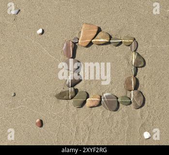 Un quadrato di pietre sulla spiaggia Foto Stock