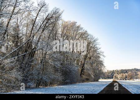 Tramonto in un bianco freddo giorno d'inverno il paesaggio. Strada attraverso la zona rurale di campi smerigliato Foto Stock