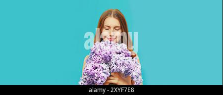 Ritratto di una bella donna che prova l'odore di fiori freschi di lilla sul fondo blu Foto Stock