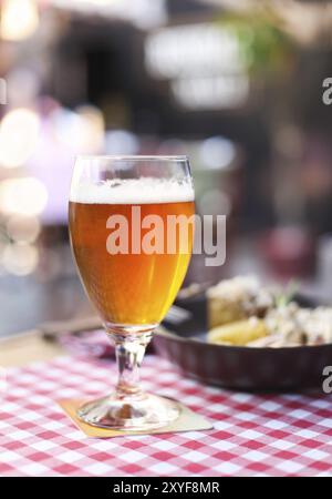 Un bicchiere di birra chiara con insalata del pub Foto Stock