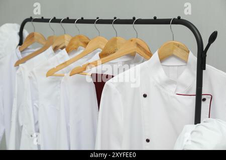 Uniformi degli chef su un appendiabiti su sfondo grigio, primo piano Foto Stock