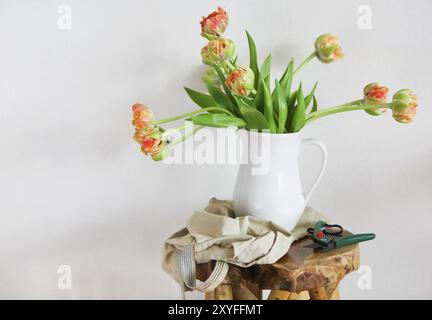 Ancora in vita con i tulipani mazzo di fiori in vaso bianco sul rustico in legno sedia Foto Stock