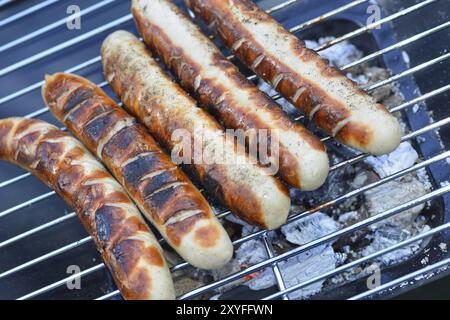 Bratwuerste auf dem Grill. La bratwurst è un tipo di salsiccia tedesca, salsiccia alla griglia Foto Stock