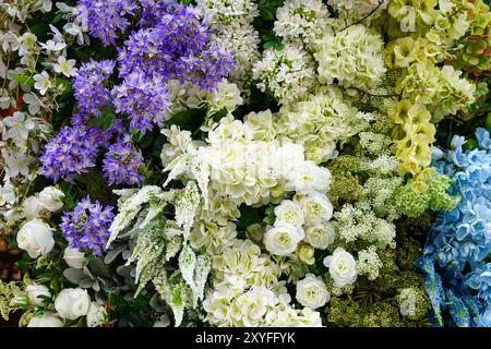 composizione floreale con una varietà di fiori bianchi, verdi, blu e viola Foto Stock