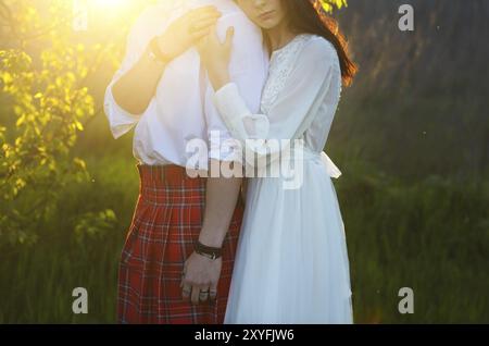 Giovane coppia felice insieme mano nella mano in sunset. Close up Foto Stock