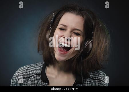 Ritratto di la bruna bellezza ragazza sorridente che indossano le cuffie Foto Stock