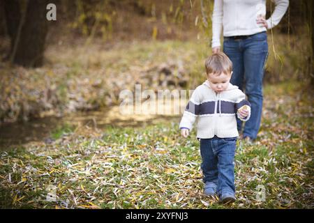 Giovane madre con figlio in autunno park. Happy family concept Foto Stock