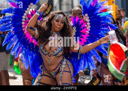 Spettacolo all'annuale Carnevale di Notting Hill, mentre i ballerini vestiti con cura nella Parata degli adulti progrediscono lentamente attraverso la parte occidentale di Londra Foto Stock