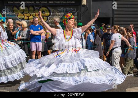 Spettacolo all'annuale Carnevale di Notting Hill, mentre i ballerini vestiti con cura nella Parata degli adulti progrediscono lentamente attraverso la parte occidentale di Londra Foto Stock