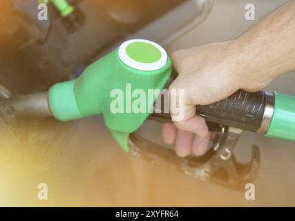 In prossimità di una mano di un uomo il rifornimento di un'auto con un gas pompa Foto Stock