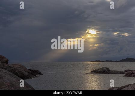 Sole che splende attraverso un'apertura in uno strato di nube densa otehrwise Foto Stock